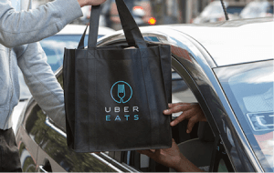 UberEats bag is being handed from one individual to another.